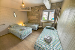 Chambre trois lits simples au très grand gîte familial au Domaine le Colombier